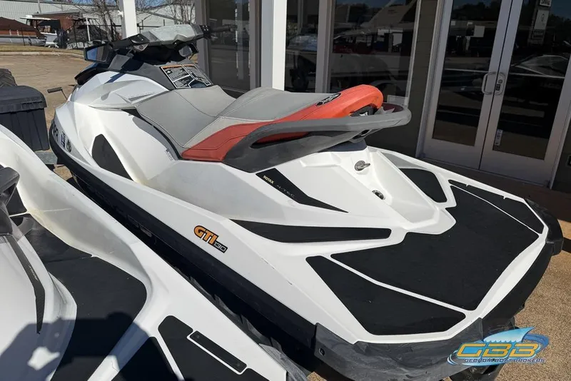 Slide: The Image of 2012 Sea-Doo GTI 130 jet ski in white and red, parked outdoors. - 5