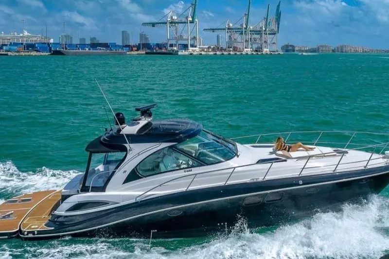The Image of 2009 Four Winns V458 yacht cruising near a port with a person relaxing on deck. - 0