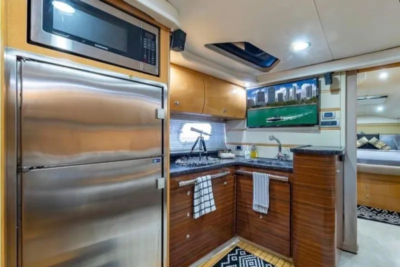 Slide: The Image of Luxurious 2009 Four Winns V458 yacht kitchen with modern appliances and elegant wood cabinetry. - 11