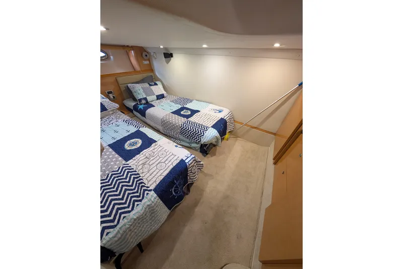 Slide: The Image of 2009 Four Winns V458 cabin with twin beds and nautical-themed bedding. - 13