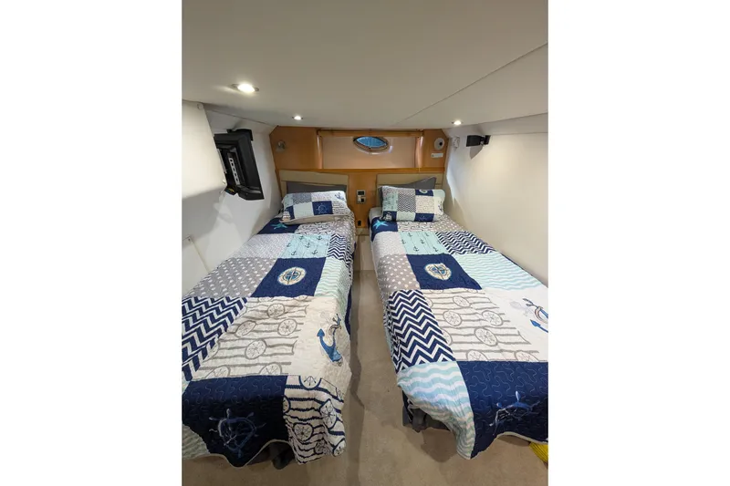 Slide: The Image of Interior of 2009 Four Winns V458 yacht with twin beds and nautical-themed bedding. - 14