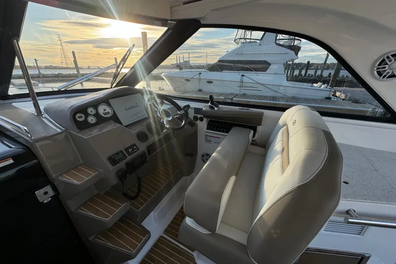 Slide: The Image of 2017 Regal 35 Sport Coupe interior with helm, steering wheel, and sunset view. - 3