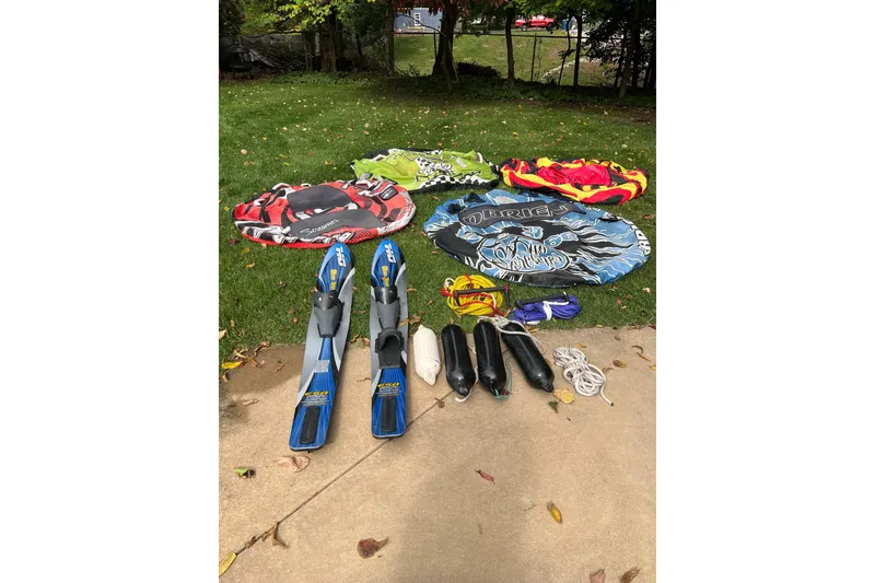 Slide: The Image of Water sports gear including tubes, skis, and ropes on grass, related to 2014 Starcraft 2000 IO Limited. - 11
