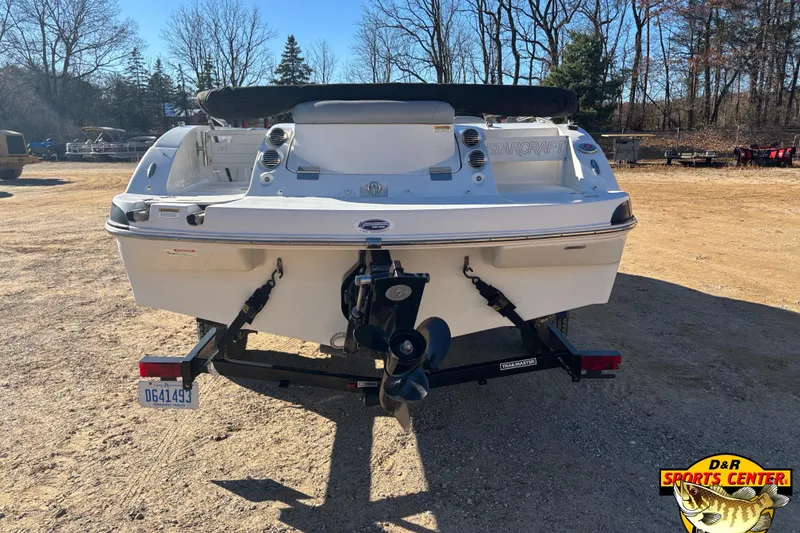 Slide: The Image of 2014 Starcraft 2000 IO Limited boat on trailer, parked outdoors in a wooded area. - 4