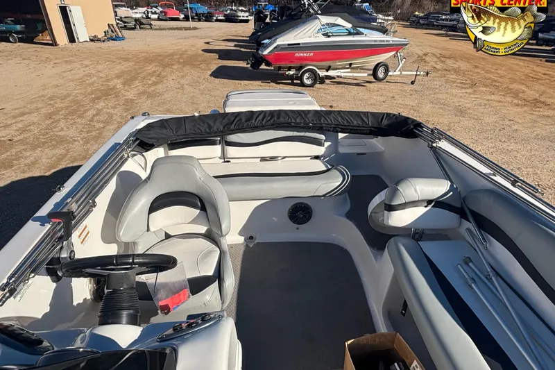 Slide: The Image of 2014 Starcraft 2000 IO Limited boat interior with seating and steering wheel, parked outdoors. - 9