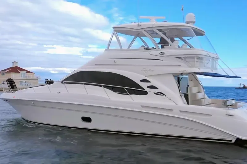 Slide: The Image of 2007 Sea Ray 58 Sedan Bridge yacht on calm waters under a blue sky. - 1