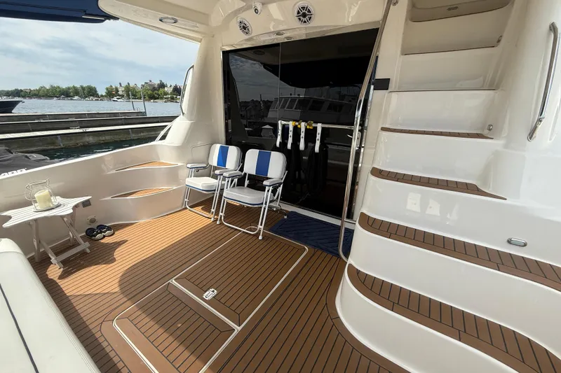 Slide: The Image of 2007 Sea Ray 58 Sedan Bridge yacht deck with chairs and table, overlooking water. - 10