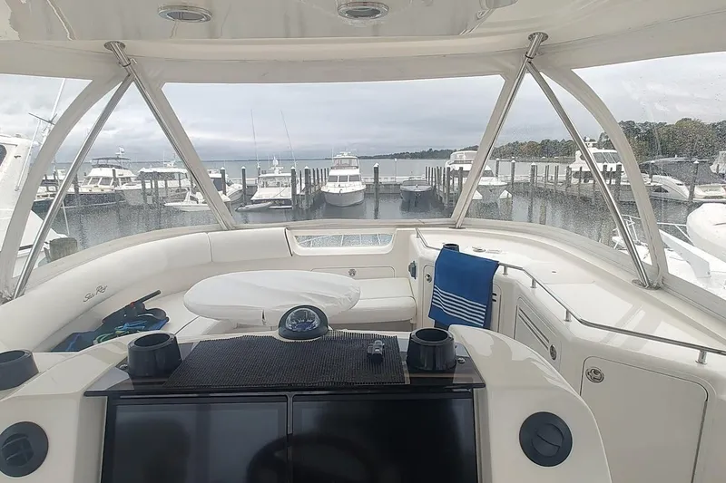 Slide: The Image of 2007 Sea Ray 58 Sedan Bridge yacht interior with marina view, featuring helm and seating area. - 13