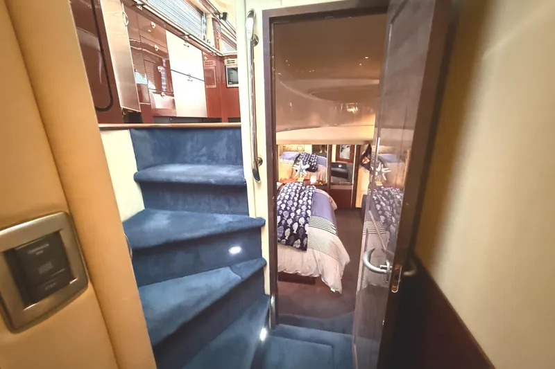 Slide: The Image of Interior of 2007 Sea Ray 58 Sedan Bridge with blue carpeted stairs and cozy bedroom. - 31