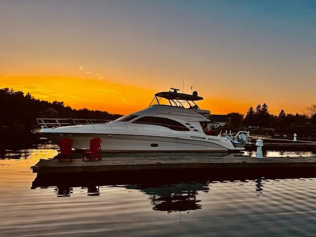 Slide: The Image of 2007 Sea Ray 58 Sedan Bridge yacht at sunset, docked on calm water. - 4