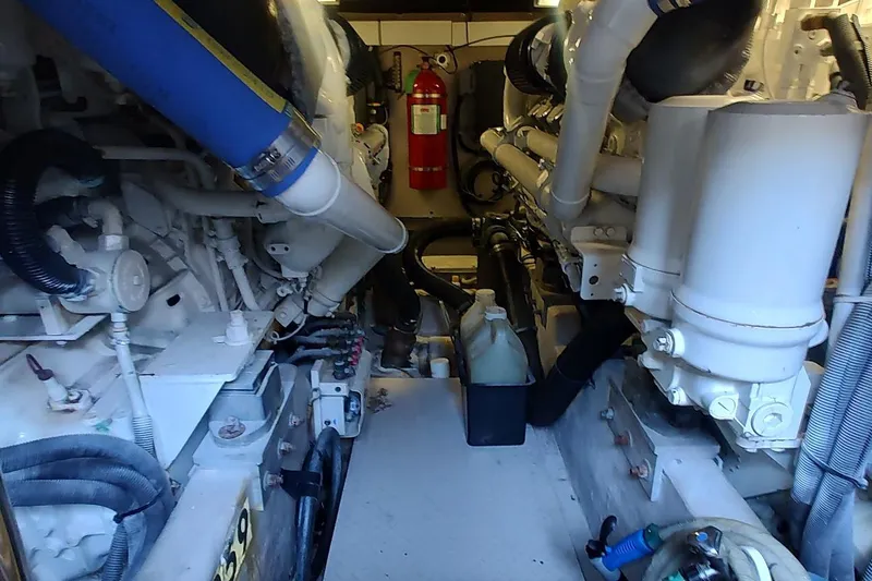 Slide: The Image of Engine room of a 2007 Sea Ray 58 Sedan Bridge yacht, featuring mechanical components and fire extinguisher. - 44