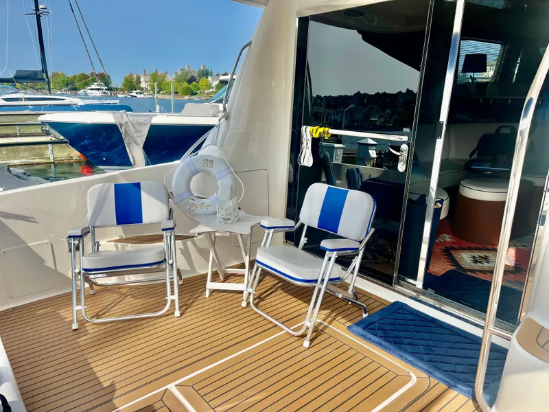Slide: The Image of 2007 Sea Ray 58 Sedan Bridge yacht deck with chairs and table, docked at marina. - 9