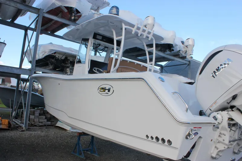 The Image of 2026 Sea Hunt Gamefish 28 Forward Seating boat with Yamaha engine, stored on a rack. - 0