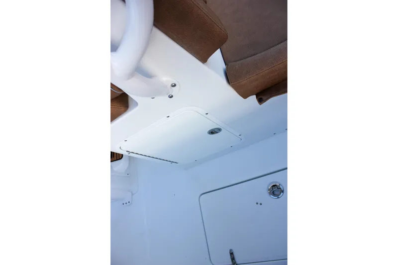 Slide: The Image of Interior view of 2026 Sea Hunt Gamefish 28 Forward Seating boat, featuring brown seating and storage compartments. - 17