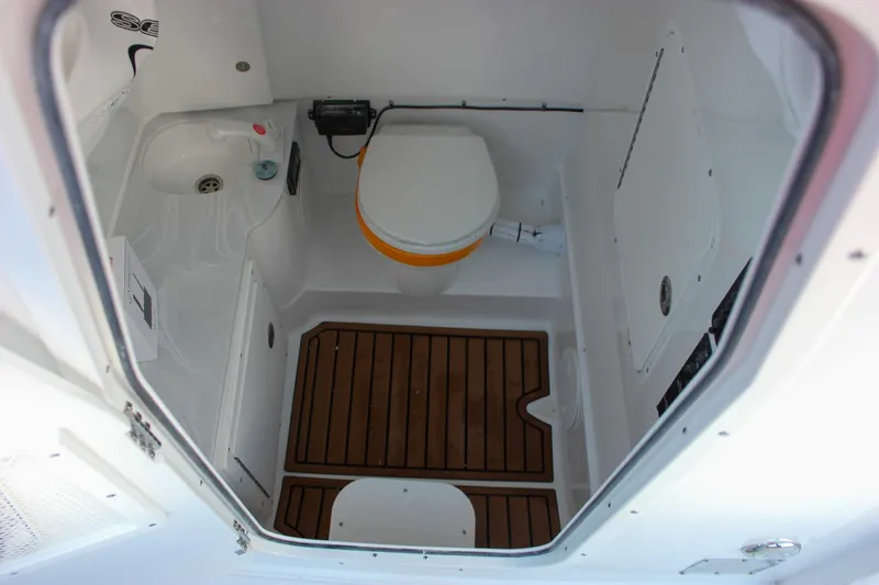 Slide: The Image of 2026 Sea Hunt Gamefish 28 boat interior with compact bathroom and wooden flooring. - 21