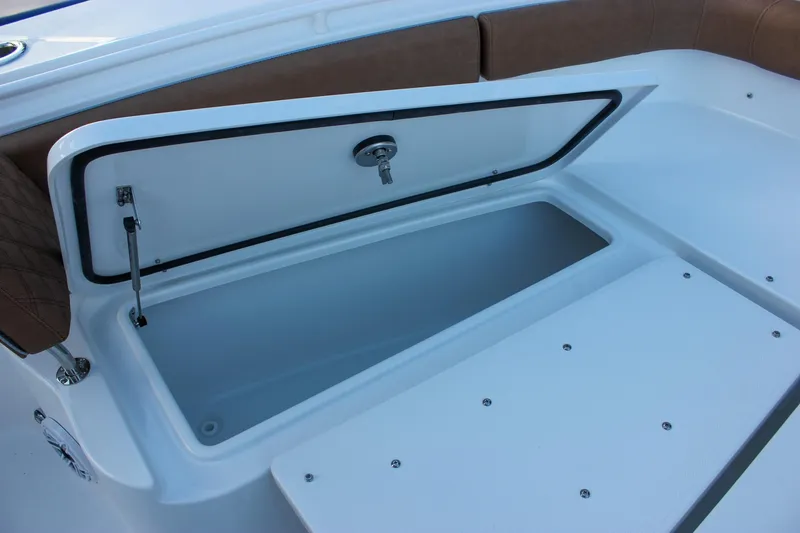 Slide: The Image of 2026 Sea Hunt Gamefish 28 Forward Seating storage compartment, open with brown cushioned seating. - 52