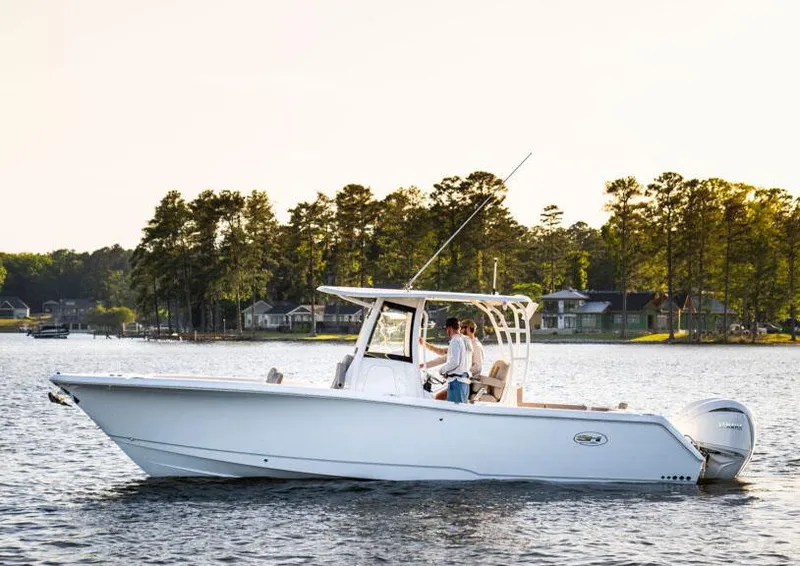 Slide: The Image of Manufacturer Provided Image: 2026 Sea Hunt Gamefish 28 boat on a serene lake with trees in the background. - 77
