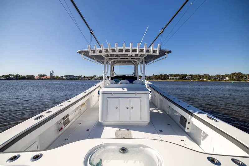 Slide: The Image of 2024 Yellowfin 39 Offshore boat on calm water, showcasing spacious deck and sleek design. - 24
