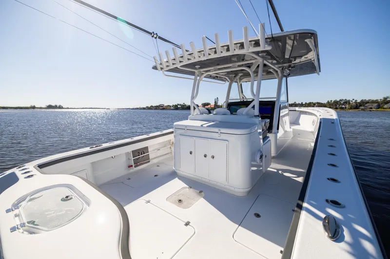 Slide: The Image of 2024 Yellowfin 39 Offshore boat on calm water, showcasing spacious deck and seating. - 25