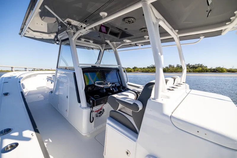 Slide: The Image of 2024 Yellowfin 39 Offshore boat interior with modern helm and seating on calm water. - 31