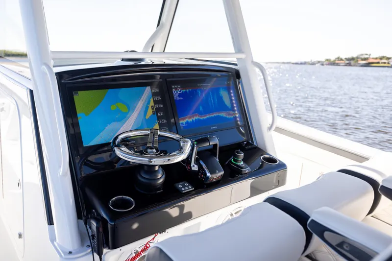 Slide: The Image of 2024 Yellowfin 39 Offshore boat dashboard with dual navigation screens and steering wheel. - 32
