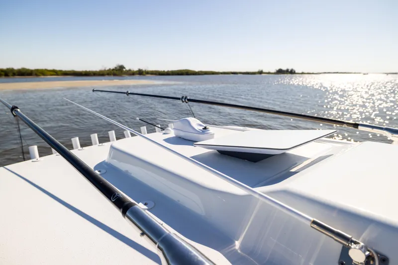 Slide: The Image of 2024 Yellowfin 39 Offshore boat with fishing rods on deck, scenic water view. - 48