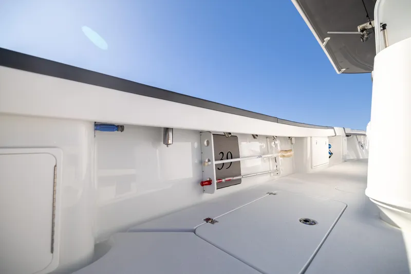 Slide: The Image of 2024 Yellowfin 39 Offshore boat deck with storage compartments under clear blue sky. - 51