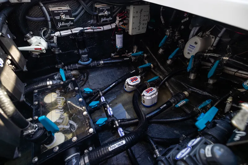 Slide: The Image of Engine compartment of 2024 Yellowfin 39 Offshore boat, showcasing intricate plumbing and wiring systems. - 59