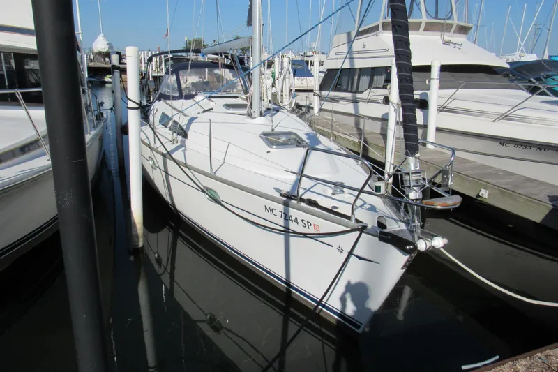Slide: The Image of 2004 Jeanneau Sun Odyssey 37 sailboat docked at marina, surrounded by other boats. - 1