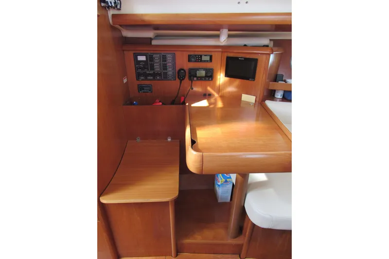 Slide: The Image of Navigation station of 2004 Jeanneau Sun Odyssey 37 sailboat with control panels and seating. - 16