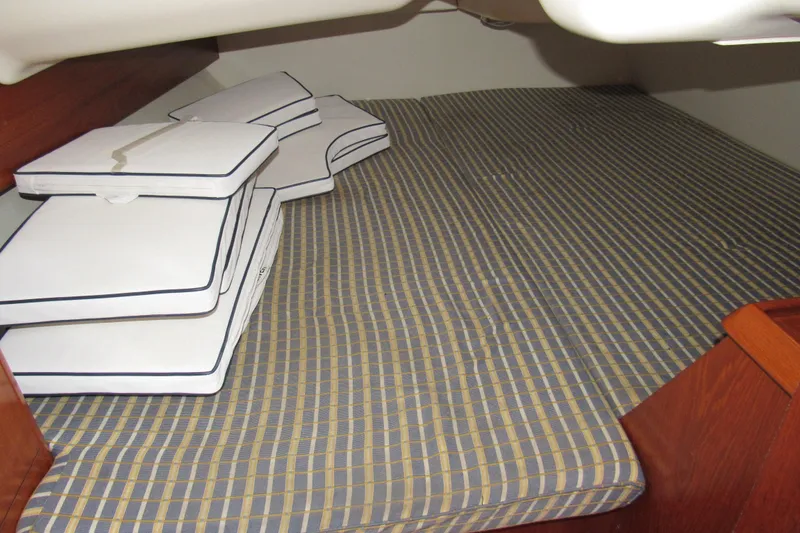 Slide: The Image of Interior cabin of 2004 Jeanneau Sun Odyssey 37 with striped bedding and stacked cushions. - 20