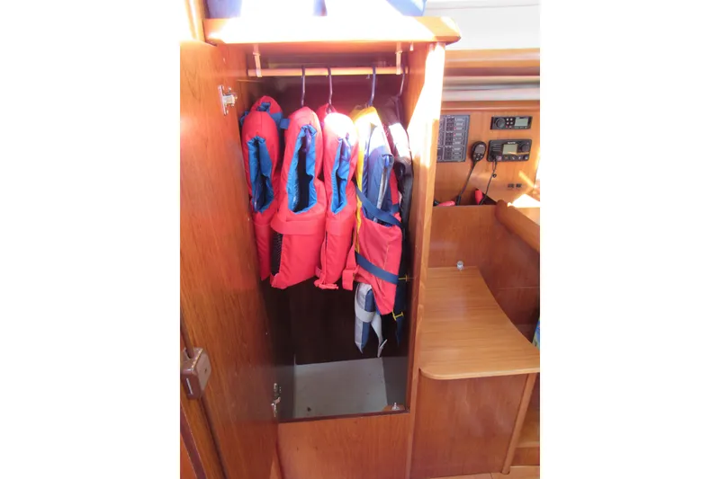 Slide: The Image of Life jackets in a wooden cabinet on a 2004 Jeanneau Sun Odyssey 37 sailboat. - 21