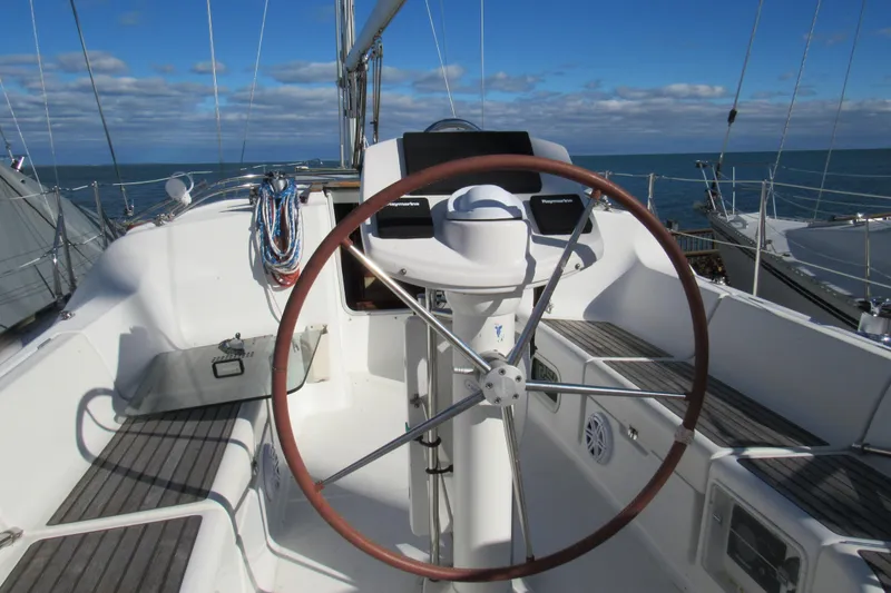 Slide: The Image of 2004 Jeanneau Sun Odyssey 37 sailboat cockpit with steering wheel and ocean view. - 23