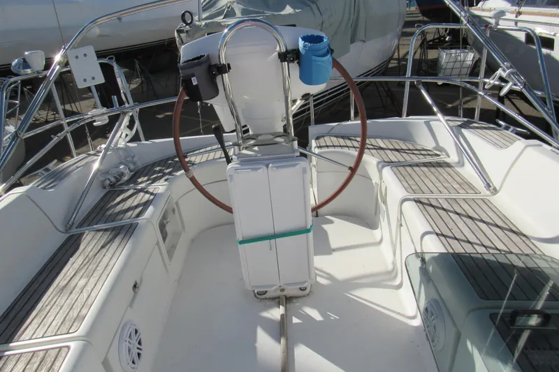 Slide: The Image of Cockpit of 2004 Jeanneau Sun Odyssey 37 sailboat with wooden seating and steering wheel. - 33