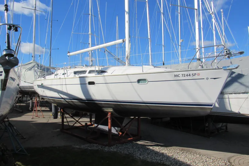 Slide: The Image of 2004 Jeanneau Sun Odyssey 37 sailboat on dry dock under clear blue sky. - 6