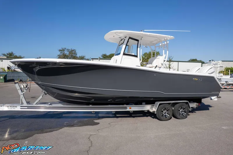 Slide: The Image of 2026 Sea Hunt Gamefish 28 Coffin Box boat on trailer, side view, outdoors. - 10