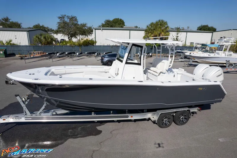 Slide: The Image of 2026 Sea Hunt Gamefish 28 Coffin Box boat on trailer, displayed outdoors. - 12