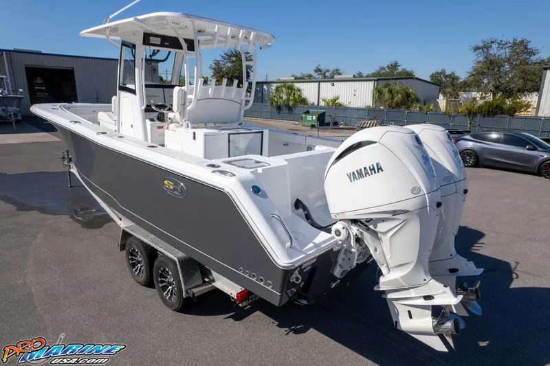 Slide: The Image of 2026 Sea Hunt Gamefish 28 Coffin Box boat with dual Yamaha engines, parked outdoors. - 18