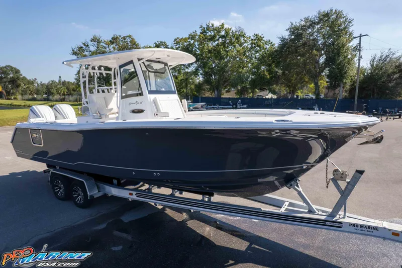 Slide: The Image of 2026 Sea Hunt Gamefish 28 Coffin Box boat on trailer, parked outdoors. - 2