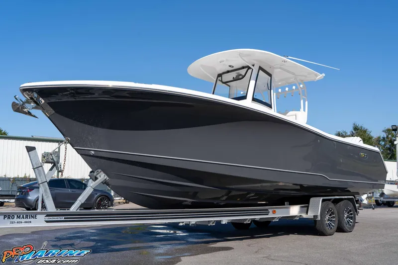 Slide: The Image of 2026 Sea Hunt Gamefish 28 Coffin Box boat on trailer, sleek design, sunny day. - 21