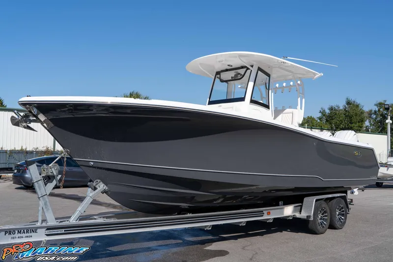 Slide: The Image of 2026 Sea Hunt Gamefish 28 Coffin Box boat on trailer, sleek design under clear blue sky. - 23
