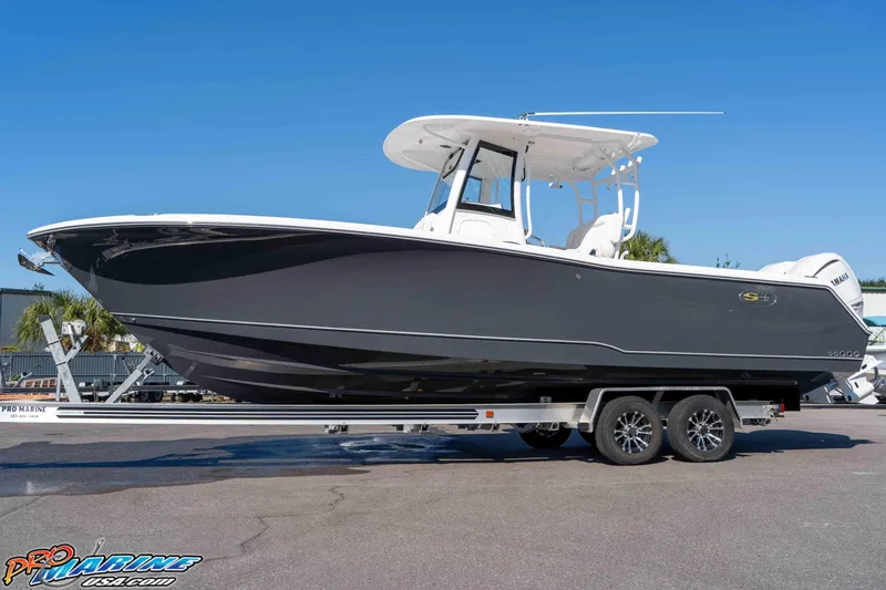Slide: The Image of 2026 Sea Hunt Gamefish 28 Coffin Box boat on trailer, side view, clear sky background. - 25