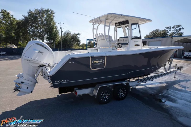 Slide: The Image of 2026 Sea Hunt Gamefish 28 Coffin Box boat on trailer, featuring Yamaha outboard motor. - 28