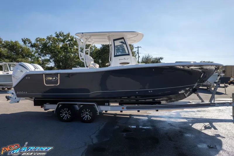 Slide: The Image of 2026 Sea Hunt Gamefish 28 Coffin Box boat on trailer, side view in sunlight. - 34