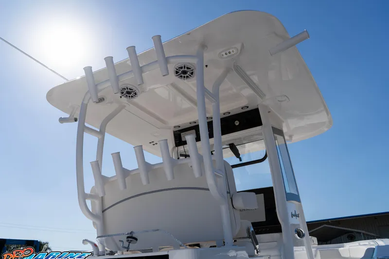 Slide: The Image of 2026 Sea Hunt Gamefish 28 Coffin Box boat, featuring rod holders and T-top under clear sky. - 41