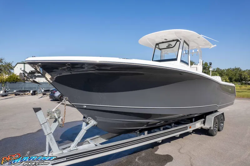 Slide: The Image of 2026 Sea Hunt Gamefish 28 Coffin Box boat on trailer, sleek design, sunny day. - 7