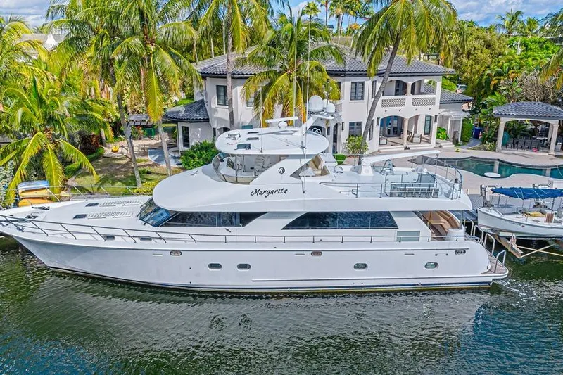 Slide: The Image of 2010 Ocean Alexander 74 Motoryacht docked by a luxurious waterfront villa. - 2