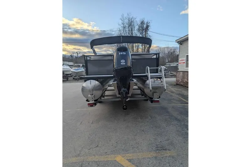 Slide: The Image of 2026 Dockside 22DQ pontoon boat with Yamaha 115 engine, parked outdoors. - 2