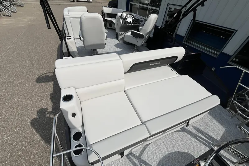 Slide: The Image of 2026 Harris Cruiser 210 boat interior with white seating and steering console. - 16