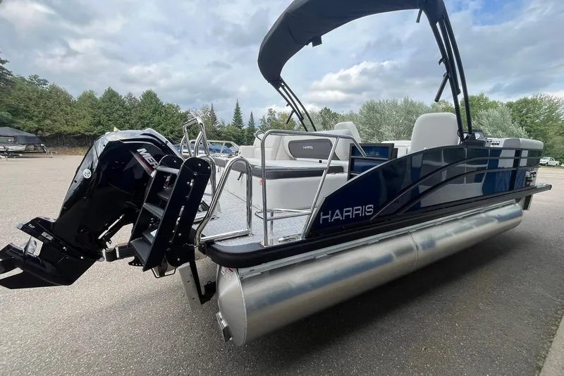Slide: The Image of 2026 Harris Cruiser 210 pontoon boat with Mercury outboard motor, parked outdoors. - 3